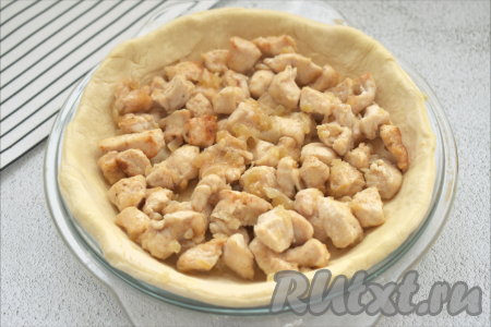 На тесто выкладываем обжаренные кусочки куриного филе.