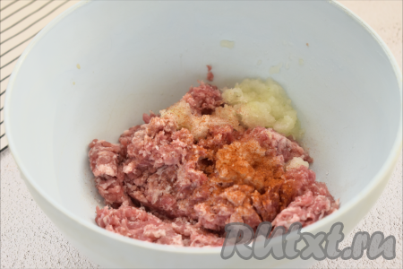 Для получения фарша для формирования фрикаделек можно взять любое мясо без костей (у меня - свинина). Моем мясо, обсушиваем, пропускаем через мясорубку в глубокую миску. Можно взять и любой покупной фарш. Лук очищаем, делим на 2 части. Одну половину луковицы пропускаем через мясорубку (или натираем на крупной тёрке) в миску с фаршем, добавляем соль и специи (я всыпала паприку). Тщательно перемешиваем фарш с луком и специями.