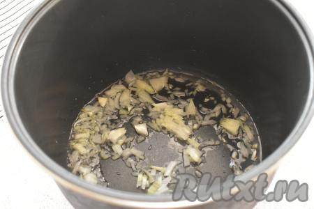 В съёмную чашу мультиварки вливаем растительное масло. Включаем режим "Жарка" на 15 минут. Вторую половину луковицы нарезаем мелко. Когда масло в мультиварке разогреется (прозвучит звуковой сигнал), выкладываем в чашу нарезанный лук, обжариваем его до прозрачности (примерно в течение 3 минут), иногда помешивая и не закрывая крышку мультиварки.