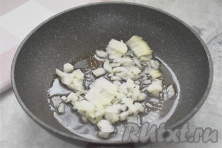 Пока варится рис, обжарим фарш. Для этого очищаем лук, нарезаем его мелко. Прогреваем растительное масло в сковороде, выкладываем мелко нарезанный лук. Обжариваем лук на среднем огне до прозрачности (минуты 3-4), иногда помешивая.