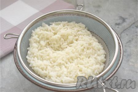 Прежде всего подготовим начинку. Для этого выкладываем сухой рис в сито, промываем хорошо под проточной водой. Промытый рис выкладываем в кастрюлю с кипящей подсоленной водой, перемешиваем, снова даём воде закипеть, уменьшаем огонь. Отвариваем рис до готовности (в течение минут 20), затем откидываем на сито, чтобы стекла вода и рис немного остыл.