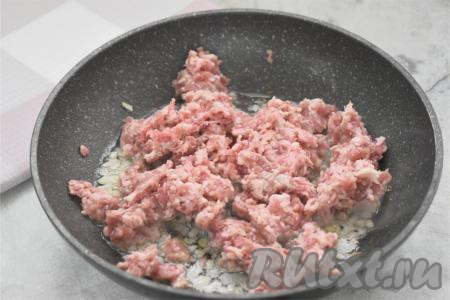 Фарш для этой выпечки можно взять и приготовленный в домашних условиях, и покупной. Подойдёт фарш из любого мяса (у меня - фарш из свинины). К луку, обжаренному до прозрачности, выкладываем фарш, перемешиваем. Обжариваем фарш с луком 8-10 минут, достаточно часто разбивая лопаткой комочки мяса. Солим фарш в процессе жарки. После того как мясо обжарится 8-10 минут, убираем сковороду с огня, даём фаршу с луком немного остыть.