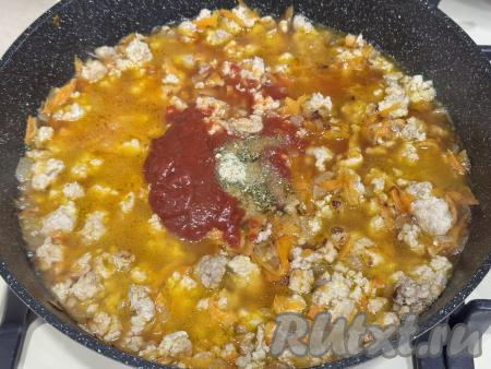 Затем в сковороду с фаршем и овощами нужно влить примерно 500 миллилитров воды, добавить томатную пасту, всыпать соль и специи по вкусу.&nbsp;