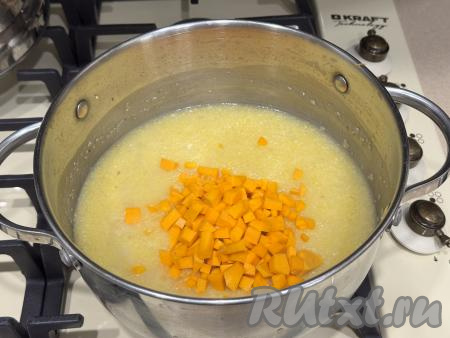 С момента закипания воды варить кукурузную кашу 15 минут, иногда помешивая. Пока каша варится, тыкву нужно очистить от кожуры и волокон с семечками. 130 гамм очищенной тыквы нарезать на мелкие кубики, чем мельче - тем лучше. По прошествии 15 минут после начала варки каши с момента закипания добавить в кастрюлю кусочки тыквы. Перемешать кукурузную кашу, дать закипеть и варить ещё 15 минут на небольшом огне, тоже иногда помешивая. В процессе варки попробовать кашу с тыквой на вкус, если необходимо, добавить сахар по вкусу.