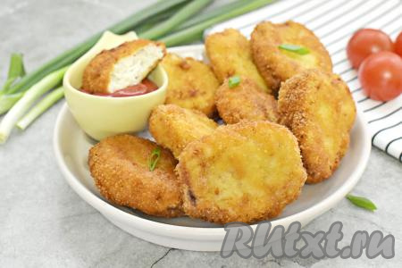 Вкусные, аппетитные наггетсы из куриного фарша, покрытые румяной, хрустящей корочкой снаружи, и нежные внутри к столу подаём, дополнив любимым соусом.