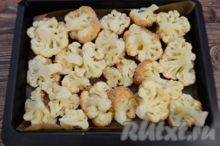 Противень застелить пергаментом. Выложить цветную капусту в панировке на противень, размещая соцветием вниз. Постепенно покрыть яйцом и сухарями все соцветия, выложить на противень.