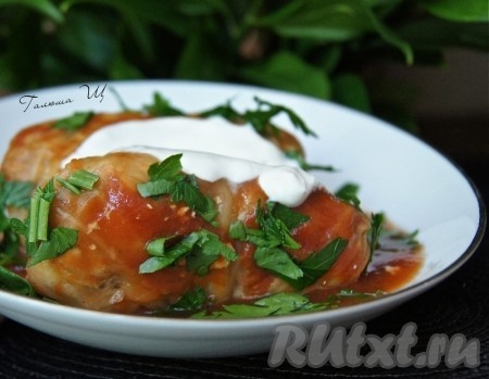 Наши вкусные, сочные голубцы в томате готовы. Подаём их горячими со сметаной и зеленью.
