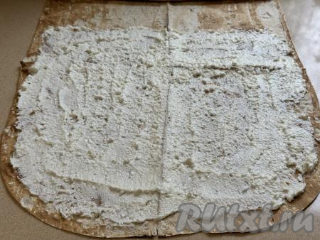 Отступая от краёв лаваша по 1 сантиметру, нанести творожную начинку на лист лаваша ровным слоем.