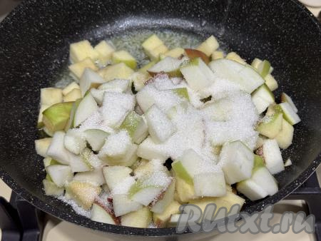 Для получения начинки нужно вымытые яблоки (очищать от кожуры я не стала) нарезать на средние кубики, удаляя семенную коробку с семечками. В сковороду выложить сливочное масло, поставить на огонь ниже среднего, сразу добавить яблоки и сахар, перемешать.