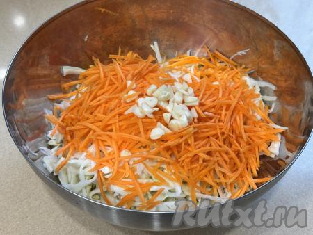 В миску с капустой добавить морковку, натёртую на крупной тёрке, и нарезанный на достаточно тонкие пластинки чеснок.&nbsp;