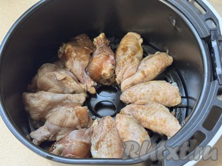 Чашу аэрогриля, по желанию, застелить фольгой, я не застилала. Куриные крылышки, промариновавшиеся в&nbsp;соево-медовом соусе, выложить в чашу аэрогриля в один слой.&nbsp;