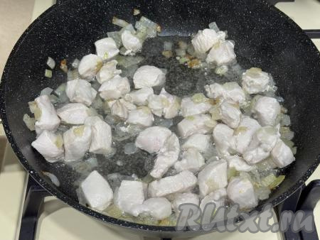 Обжарить кусочки мяса курицы с луком в течение 10 минут, периодически перемешивая.&nbsp;