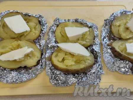 Готовый запечённый картофель, достать из аэрогриля, развернуть фольгу. С фольги картошку убирать не нужно.&nbsp;Разрезать каждую картошину вдоль на 2 части.  Вилкой размять мякоть картошки. Сверху на каждую половинку картошки выложить небольшой кусочек сливочного масла.