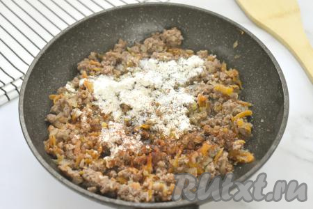 Затем к фаршу, обжаренному с овощами, добавляем муку, специи (у меня - паприка и чёрный молотый перец), солим. Перемешиваем, равномерно распределяя муку по фаршу.