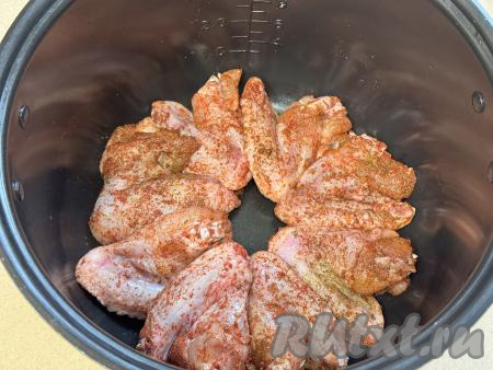 По прошествии 30 минут куриные крылья, промариновавшиеся в специях, выложить в один слой в чашу мультиварки.&nbsp;