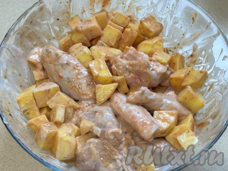 Хорошо перемешать картошку с крыльями, покрывая их томатной пастой и сметаной со всех сторон.