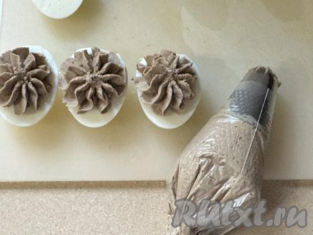 Выложить печёночную массу в кулинарный мешок и отсадить в лодочки из белка. Можно просто выложить массу ложкой.&nbsp;