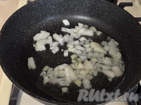Прогреть растительное масло в сковороде, после этого выложить мелко нарезанный лук, иногда помешивая, обжарить его на среднем огне до прозрачности (ориентировочно в течение 3-4 минут).&nbsp;