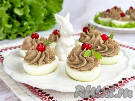 Яйца, фаршированные куриной печенью, выложить на тарелку (при подаче я украсила ягодами клюквы) и подать очень красивую и вкусную закуску к повседневному или к праздничному столу.