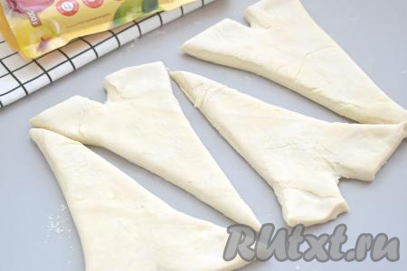 У основания каждого треугольника из теста делаем небольшой надрез по середине. Углы теста рядом с надрезами разводим в стороны, как на фото.
