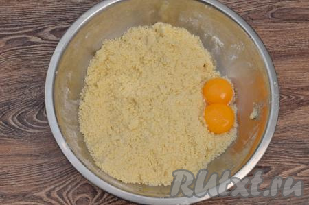 Масло с сухими ингредиентами перетереть руками до получения мелкой, однородной песочной крошки.&nbsp;В миску с песочной крошкой выложить желтки.