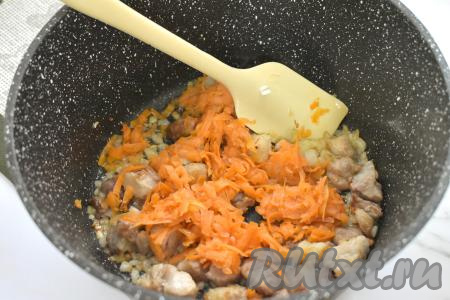 К свинине, обжаренной с луком, добавляем морковку, натёртую на крупной тёрке, перемешиваем. Обжариваем мясо с овощами 5 минут, время от времени перемешиваем.&nbsp;