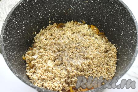 Пока тушится мясо, выкладываем ячневую крупу в сито, хорошо промываем проточной водой, даём стечь лишней жидкости. После того как свинина с овощами с момента закипания воды протушится 10 минут, добавляем к ним подготовленную ячневую крупу, по вкусу солим и перчим.