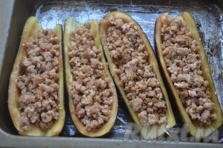 В "лодочки" из баклажанов выложить первым слоем мясной фарш с луком.