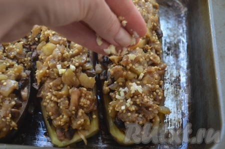 Чеснок мелко порезать, посыпать баклажаны. Запекать баклажаны 10-15 минут в духовке при температуре 200 градусов.