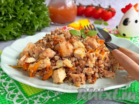 Рассыпчатую гречку вместе с нежными кусочками копчёной курицы разложить со сковороды по тарелкам и в горячем виде подать вкусное, очень ароматное и сытное блюдо к столу.