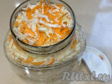 Капусту, смешанную с морковью и имбирём, переложить в двухлитровую банку.