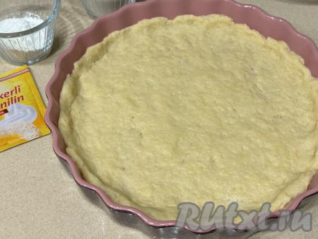 Разделить тесто на две части. Одну часть поместить в целлофановый пакет и убрать в морозилку на 30 минут. Вторую часть теста выложить в форму для выпечки и распределить по форме, сформировав невысокий бортик. Я взяла форму диаметром 26 сантиметров.