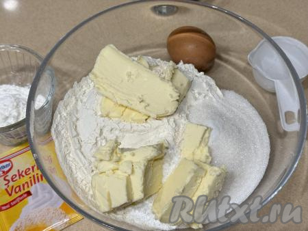 Сливочное масло достать из холодильника, нарезать на кусочки и сразу выложить в миску с сухими ингредиентами.