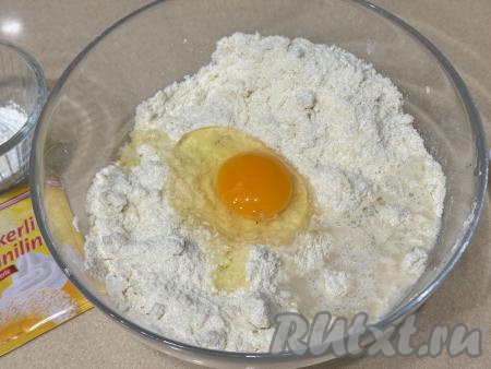 В миску с крошкой добавить сырое яйцо и 2 столовых ложки холодной воды, перемешать тесто столовой ложкой.