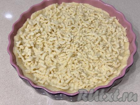 Достать тесто из морозилки, натереть его на крупной тёрке. Равномерно выложить натёртое тесто поверх начинки, покрывая весь лимонный слой.