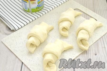 Начиная с основания треугольника, сворачиваем каждую заготовку из теста в рулетик. Кончик теста должен быть снизу. Аналогично формируем все заготовки круассанов.