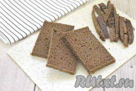 Нарезаем чёрный хлеб на ломтики толщиной 1 сантиметр. По желанию отрезаем корочки у хлеба.