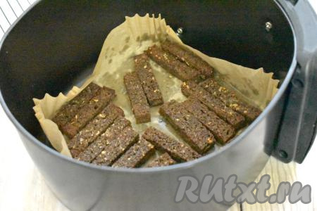 Выставляем температуру на 170 градусов, а время - на 10-13 минут. Через 5-6 минут с начала запекания переворачиваем сухарики с чесноком на другую сторону и продолжаем готовить ещё 5-8 минут. У меня аэрогриль мощностью 1400 Ватт, я готовила чесночные сухарики 13 минут.