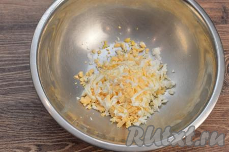 Пока минтай остывает, нужно натереть варёные яйца на крупной тёрке в глубокую миску.
