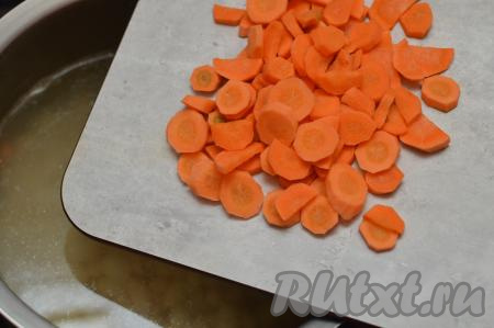 После того как фасоль сварится, добавить в кастрюлю очищенную морковку, нарезанную на достаточно тонкие кружочки (или полукружочки). В этот суп я добавляю достаточно много морковки, она делает фасолевый суп более ярким.