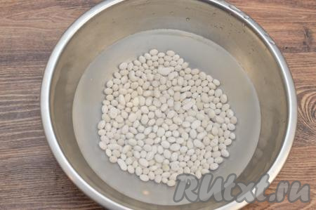Для того чтобы сухая фасоль сварилась быстрее, желательно замочить её с вечера. Для этого нужно взять 190 грамм сухой фасоли (это примерно 1 стакан объёмом 200 миллилитров), выложить в сито, хорошо промыть проточной водой, лишней воде дать стечь. Промытую фасоль выложить в глубокую миску, залить достаточно большим количеством воды и оставить на ночь.&nbsp;