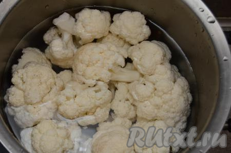 Выложить капусту в кастрюлю, залить полностью водой и поставить на сильный огонь. Как только вода закипит, уменьшить огонь. Варить цветную капусту до готовности (в течение 5-7 минут). Соцветия должны стать достаточно мягкими, легко прокалываться ножом, но при этом они должны хорошо держать форму.