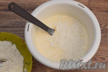 Всыпать грамм 100 муки, перемешать тесто, полностью вмешивая муку, как бы складывающимися движениями лопатки снизу вверх.