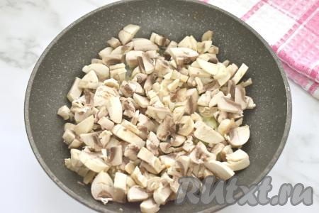 К обжаренному луку выкладываем шампиньоны (или отваренные лесные грибы), нарезанные некрупно, перемешиваем.&nbsp;Обжариваем грибы с луком, время от времени перемешивая, до испарения влаги (примерно 7-10 минут). В процессе обжаривания солим грибы по вкусу. Жареные грибы убираем с огня, даём немного остыть.