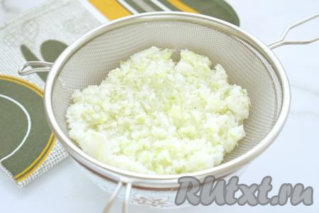 Измельчённую капусту перекладываем в миску, заливаем кипящей водой и оставляем на 10 минут. Затем капусту выкладываем на сито и хорошо отжимаем, убирая лишнюю воду.