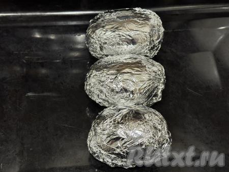 Картошины, плотно завёрнутые в фольгу, выложить в форму для запекания (или на противень) и отправить в духовку, разогретую до 200 градусов, на 40-45 минут (запекать до готовности). Для того чтобы проверить готовность картофеля, нужно прямо сквозь фольгу проколоть картошку зубочисткой, если зубочистка входит легко, значит картофель готов и нужно доставать его из духовки.&nbsp;