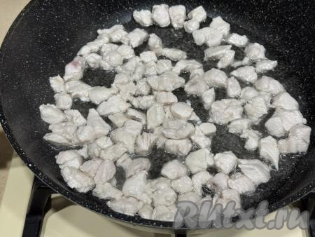 Обжарить кусочки мяса курицы в течение 10 минут, периодически перемешивая.&nbsp;