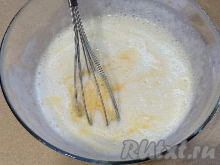 В процессе гашения соды в миске на поверхности кефира появятся пузырьки, смесь немного увеличится в объёме. В миску со смесью кефира и соды добавить соль, сахар, 1 сырое яйцо, перемешать смесь венчиком.&nbsp;