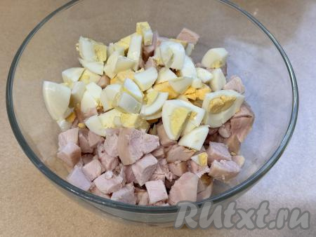 В миску с курицей добавить варёные яйца, нарезанные на средние кубики.&nbsp;