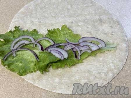 Затем на салат разложить полукольца лука.